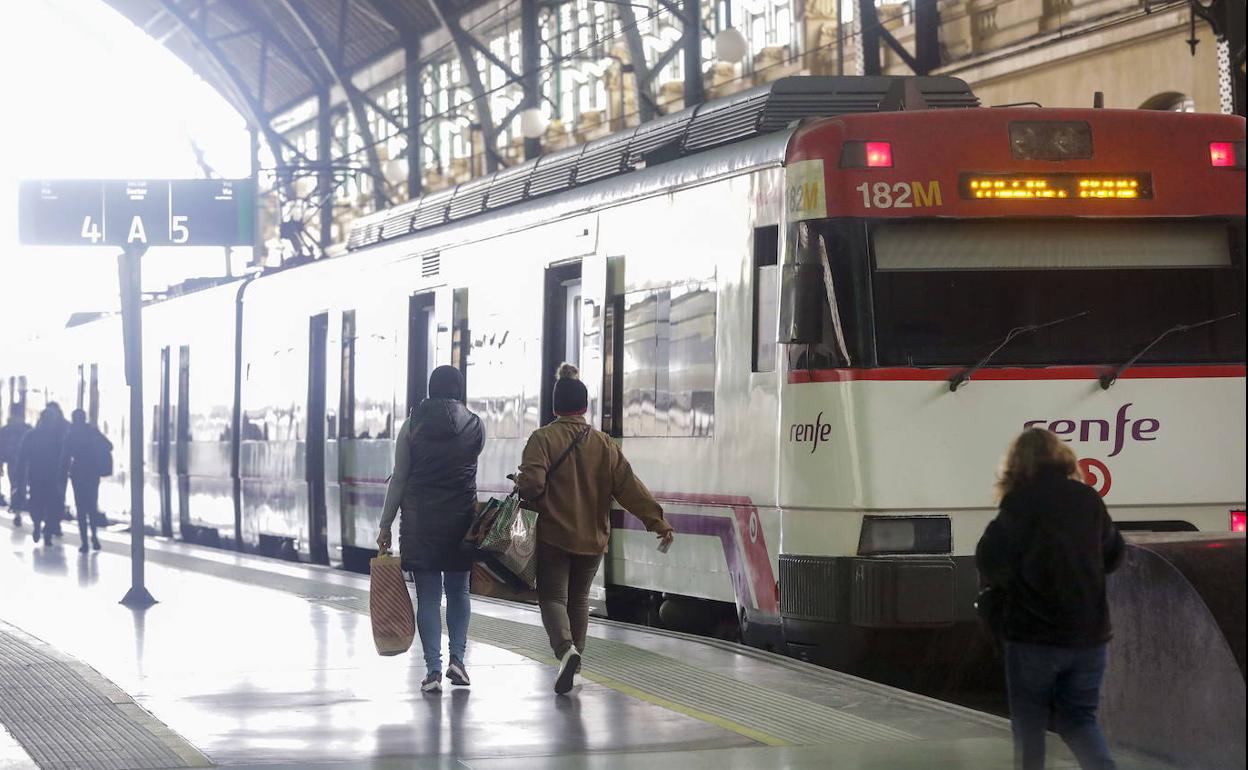 Pasajeros junto a un tren de Cercanías en la estación del Norte. 