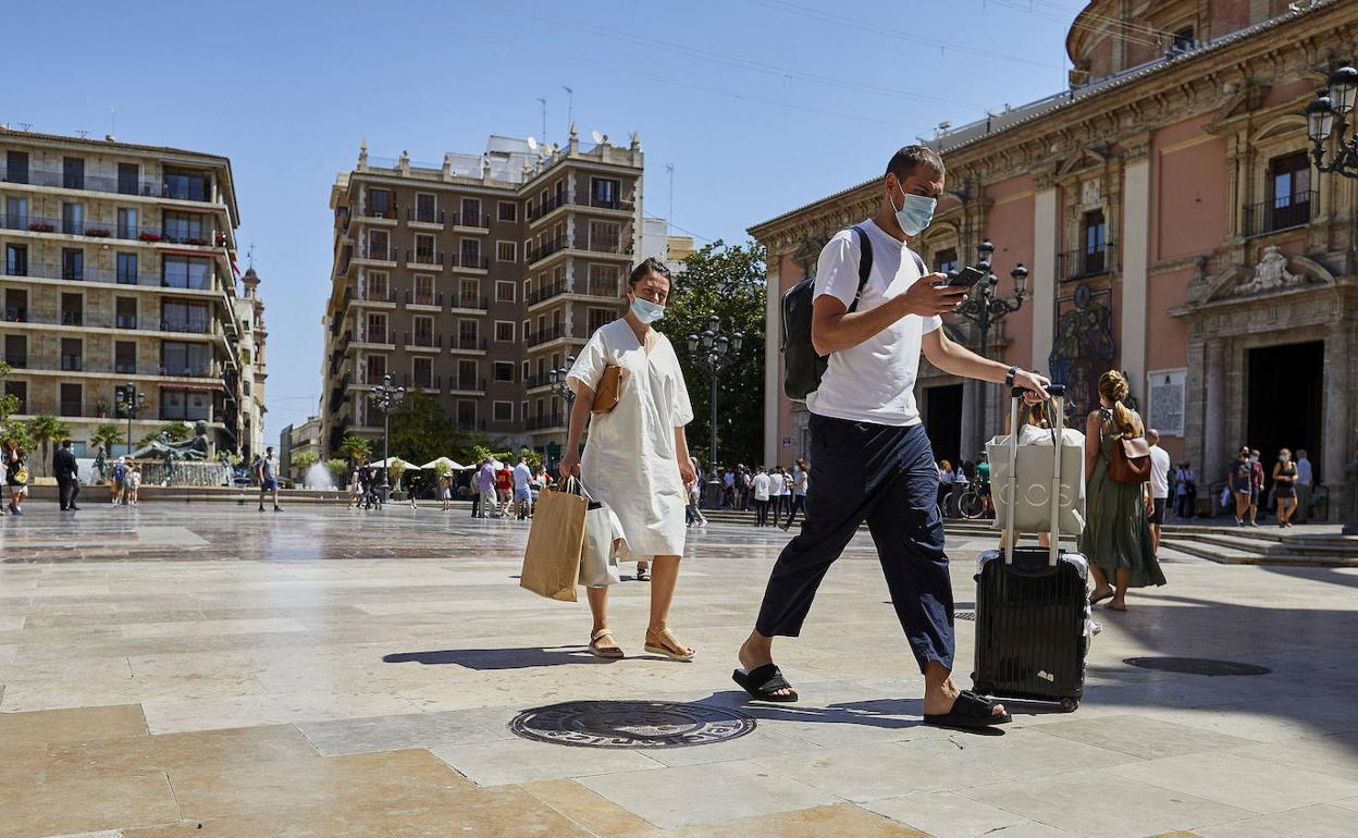 Imagen de archivo de unos turistas paseando por la plaza de la Virgen de Valencia.