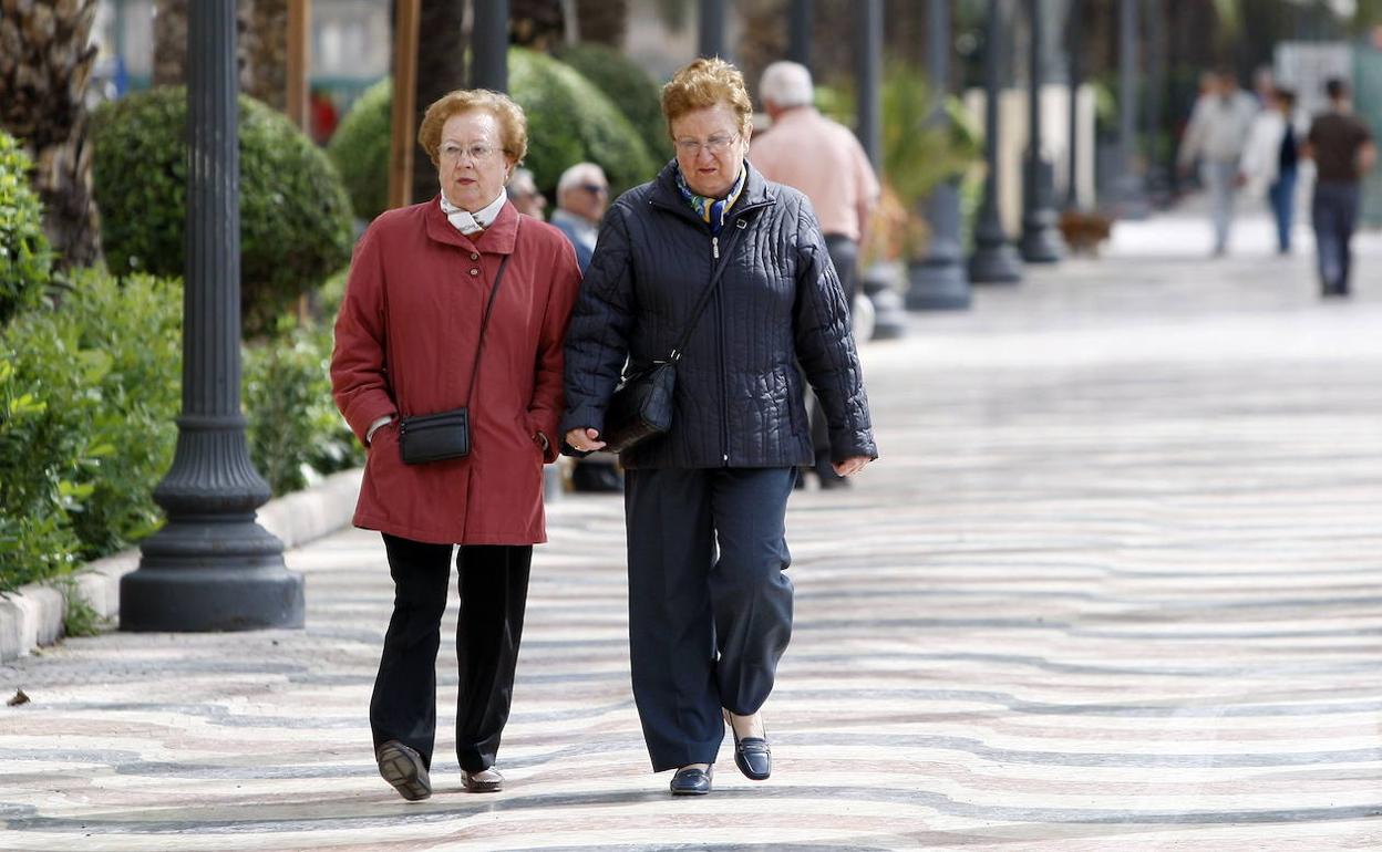 Dos mujeres pasean abrigadas por la Explanada de Alicante. 