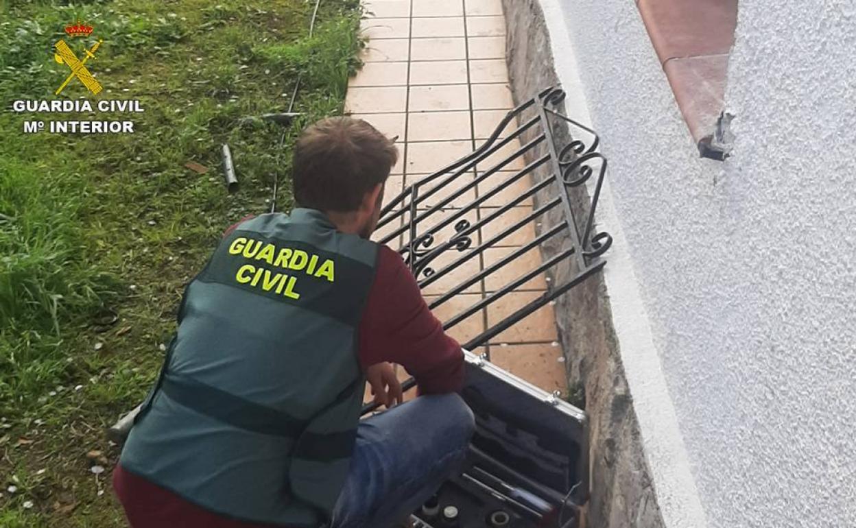 Un agente del Equipo Roca de Calp examina una reja en una de las casas. 