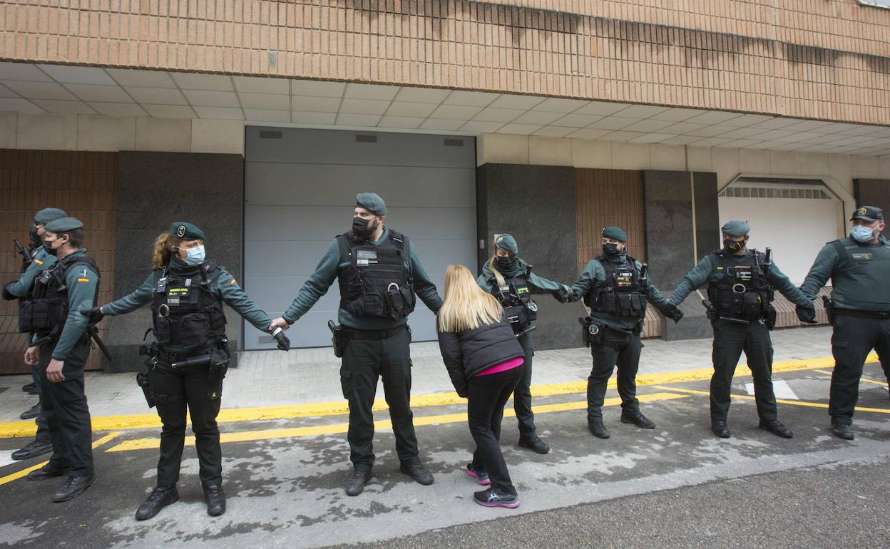 Una mujer se aproxima a un cordón policial junto a los juzgados de Sueca durante el traslado del sospechoso de asesinar a su hijo. 