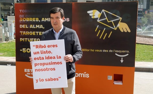 Giner, con el cartel contra Ribó, ante el cartel de Ribó.