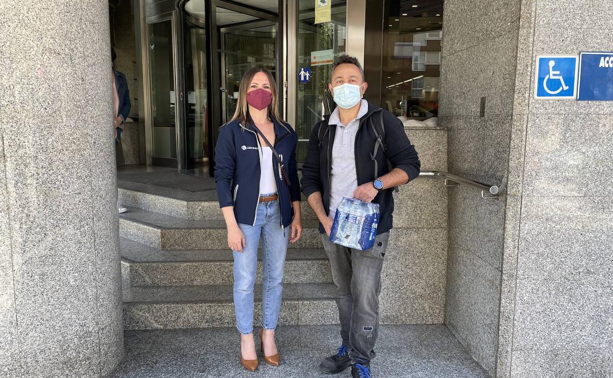 Los dos representantes vecinales cargados con las botellas de agua. 