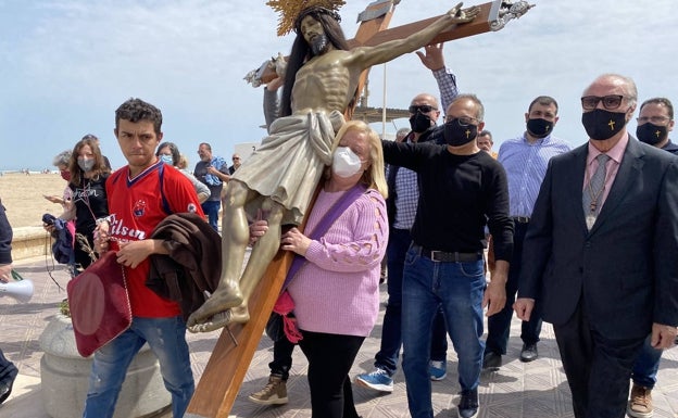 Laura Molina, mujer que donó de joven su pelo para el Cristo, portando la imagen. 