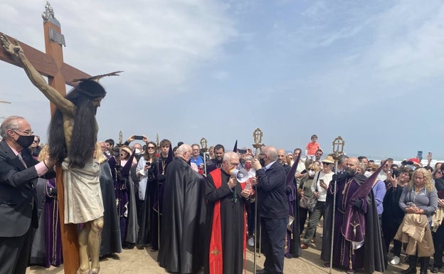 Imagen principal - Oración en la orilla, una mujer besa un clavel antes de lanzarlo al mar y Cristo portado por cofrades. 