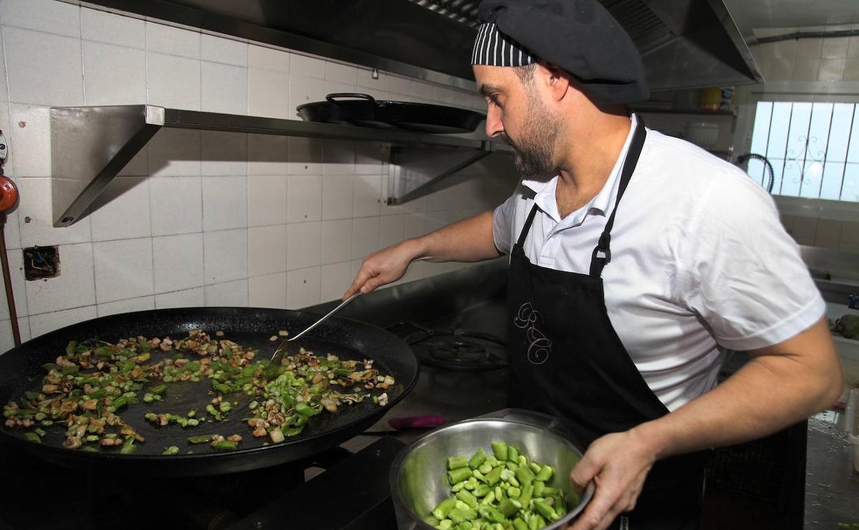 El chef del restaurante La Cumbre preparando la paella de sepia y habas. 