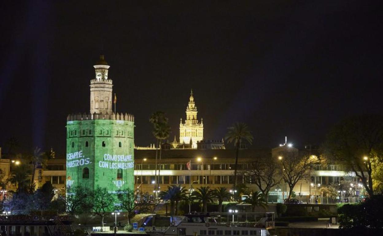 Sevilla, iluminada por la noche con mensajes de apoyo al Betis.