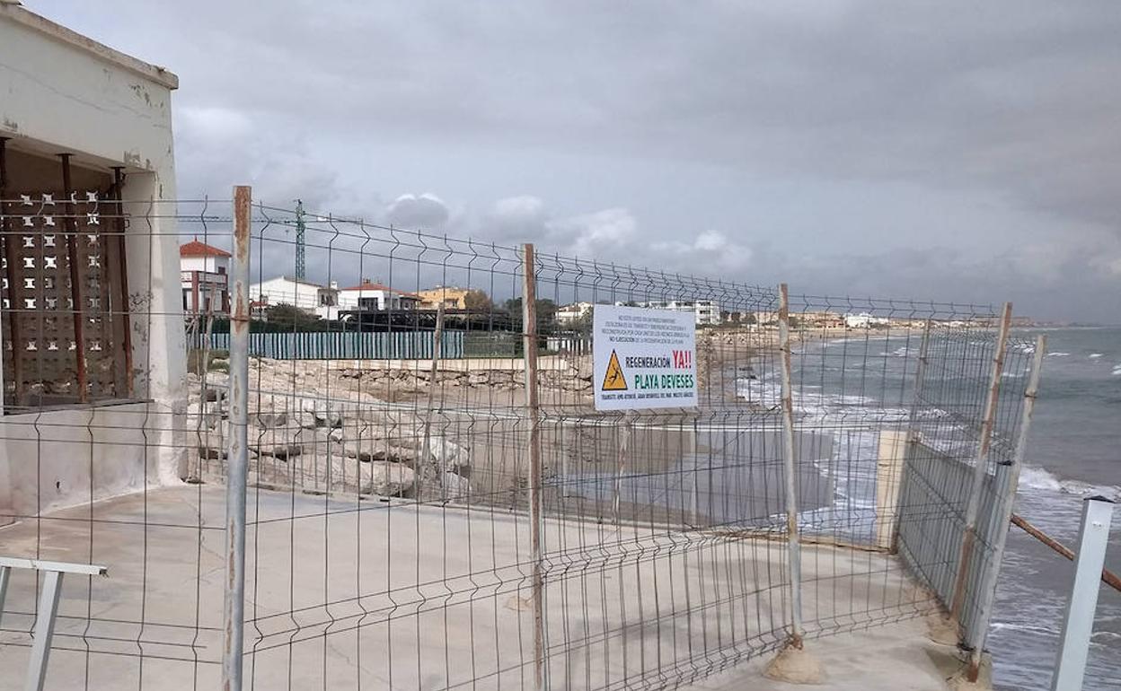 Un cartel en Les Deveses que pide la regeneración de la playa. 