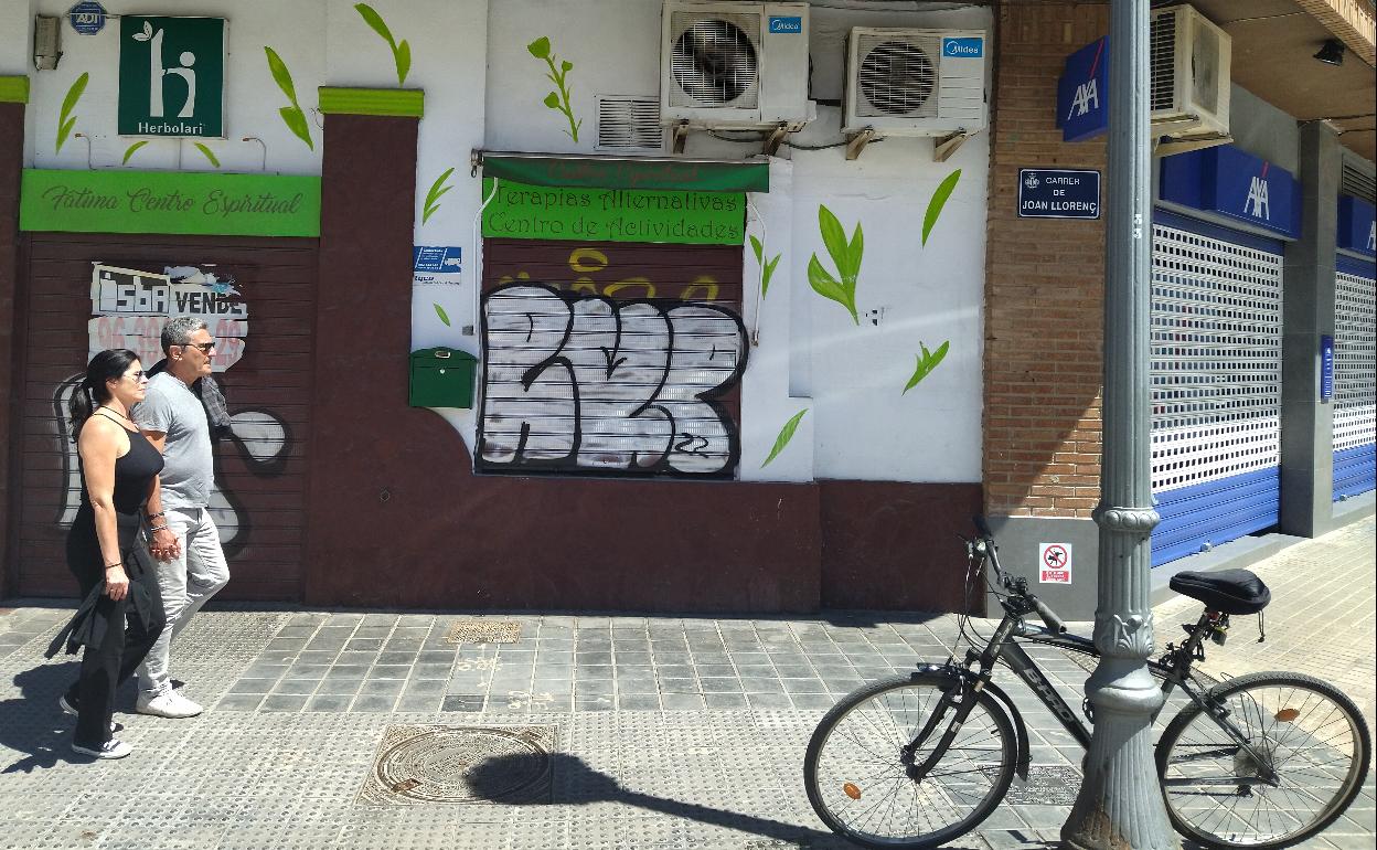 Una pareja camina junto a la tienda que regentaban los estafadores. 