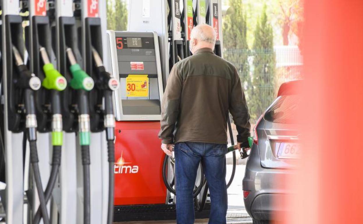 Un hombre repone combustible en su vehículo