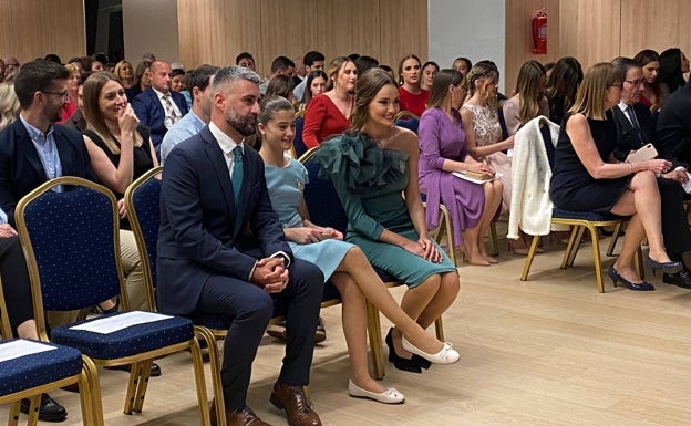 Imagen principal - El concejal Pere Fuset, junto a Carla García y Consuelo Llobell, escenario del acto con un retrato y Consuelo con un traje de la diseñadora Isabel Serrano. 