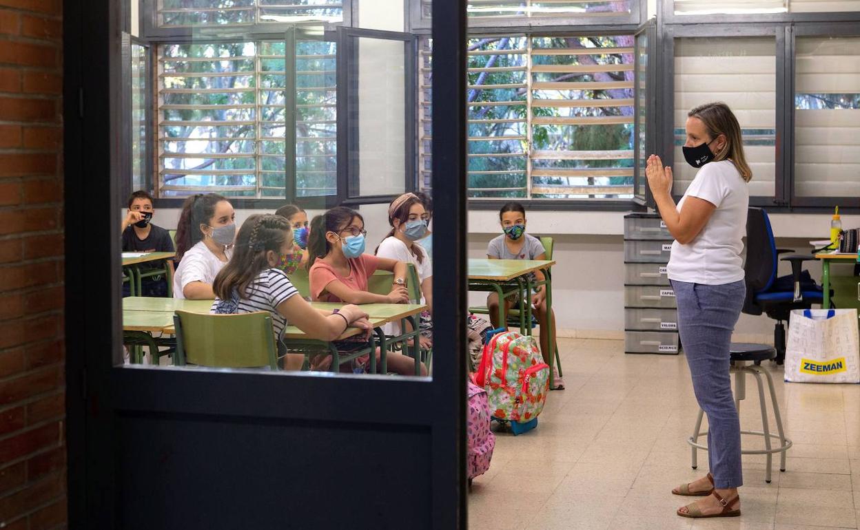 Una profesora da la bienvenida a sus alumnos el primer día el curso 2020-2021. 