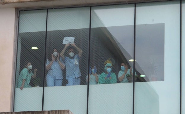 Desde las ventanas el personal que trabaja muestra su apoyo a la protesta. 