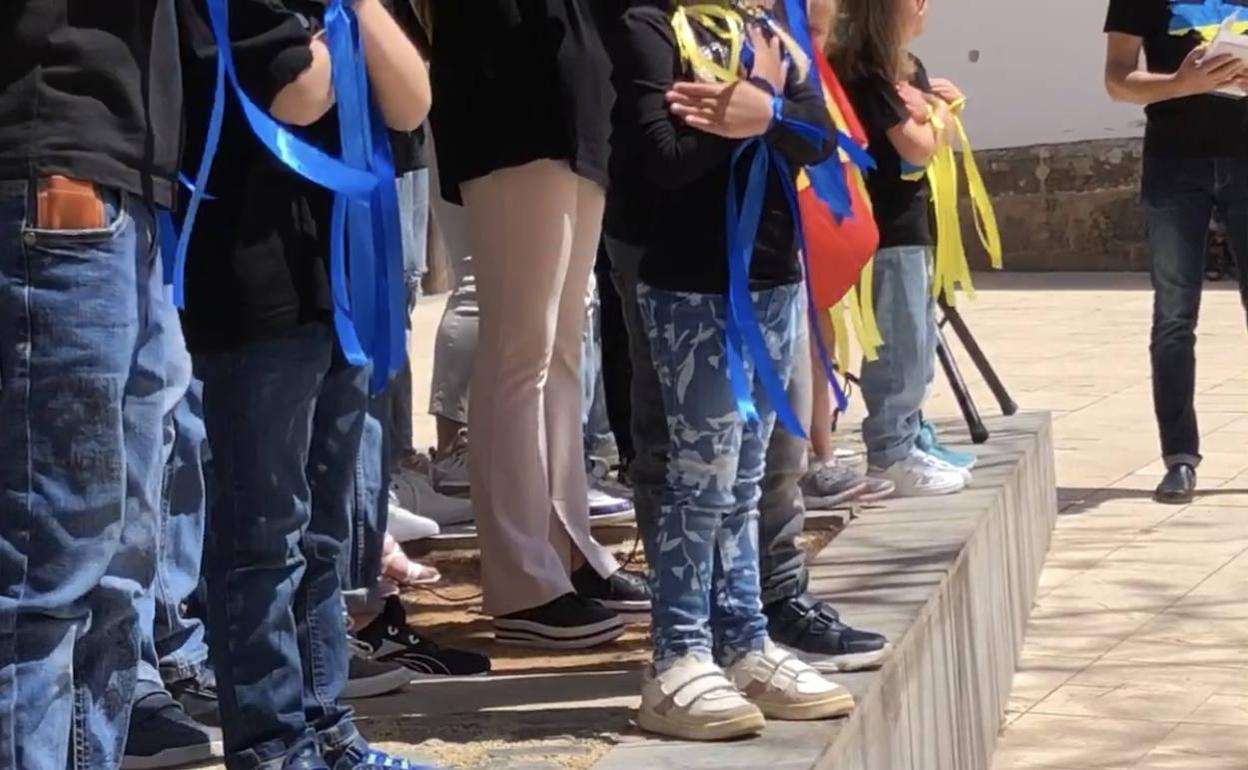 Niños ucranianos con cintas azules y amarilla en el acto de agradecimiento a la población de Dénia. 