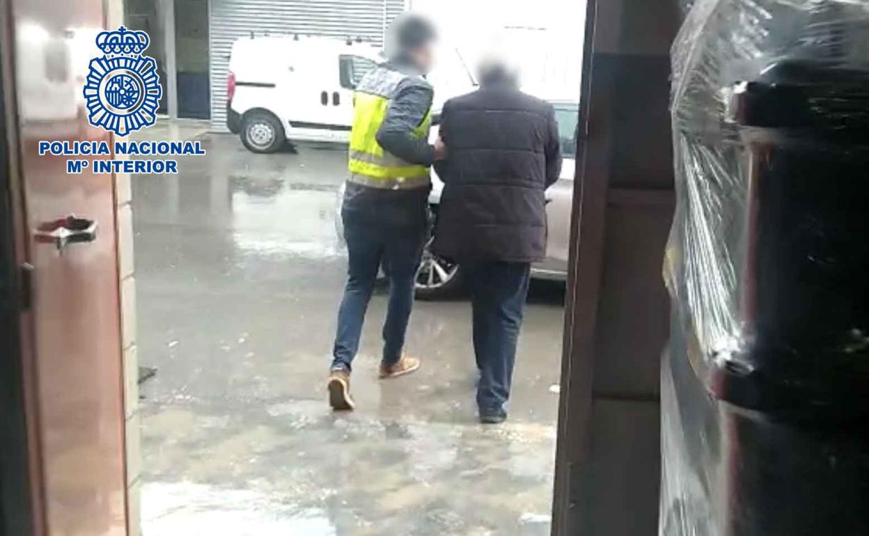 Un agente acompaña al detenido. 