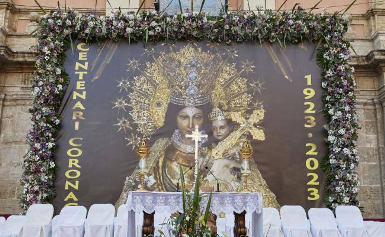 Lona con la imagen de la Virgen de los Desamparados y con un ribete de flores. 