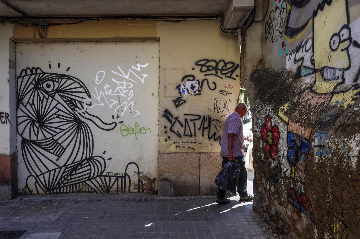 Un hombre cruza por el agujero del barrio de Orriols. 