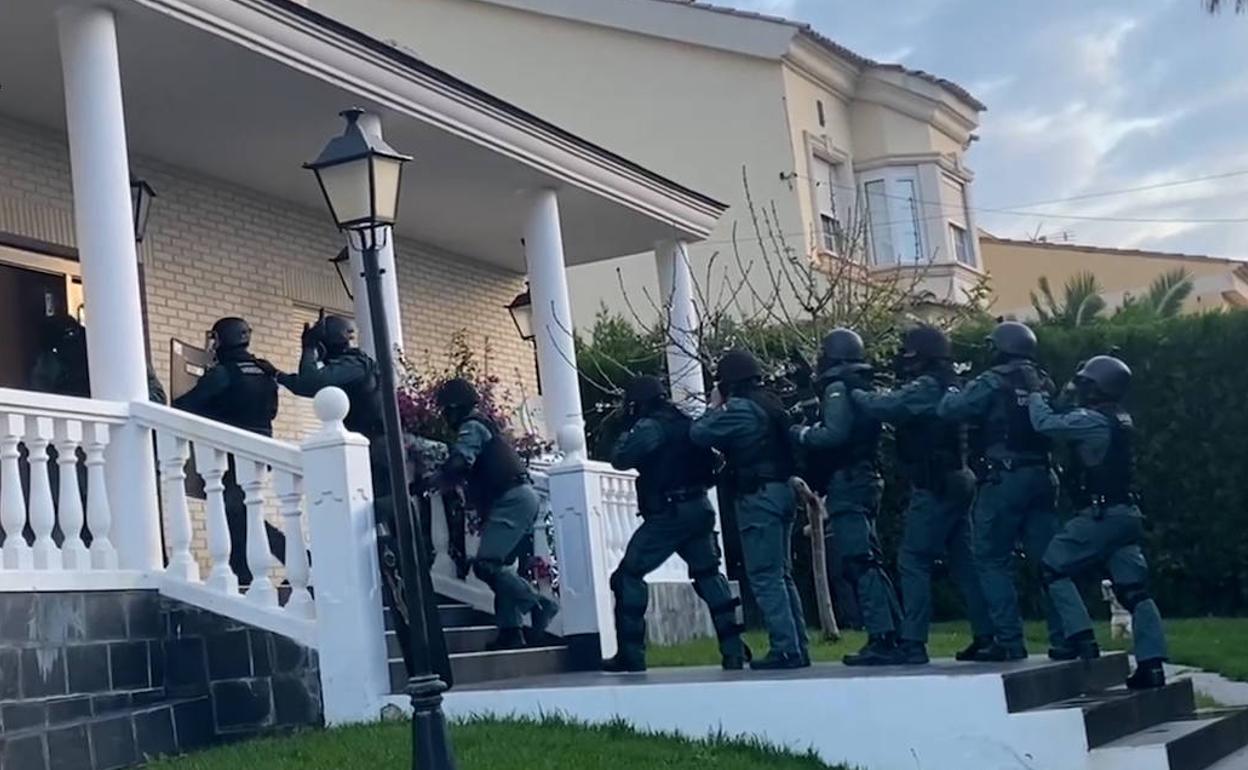 Agentes de la Guardia Civil entrando al chalé de Godelleta. 