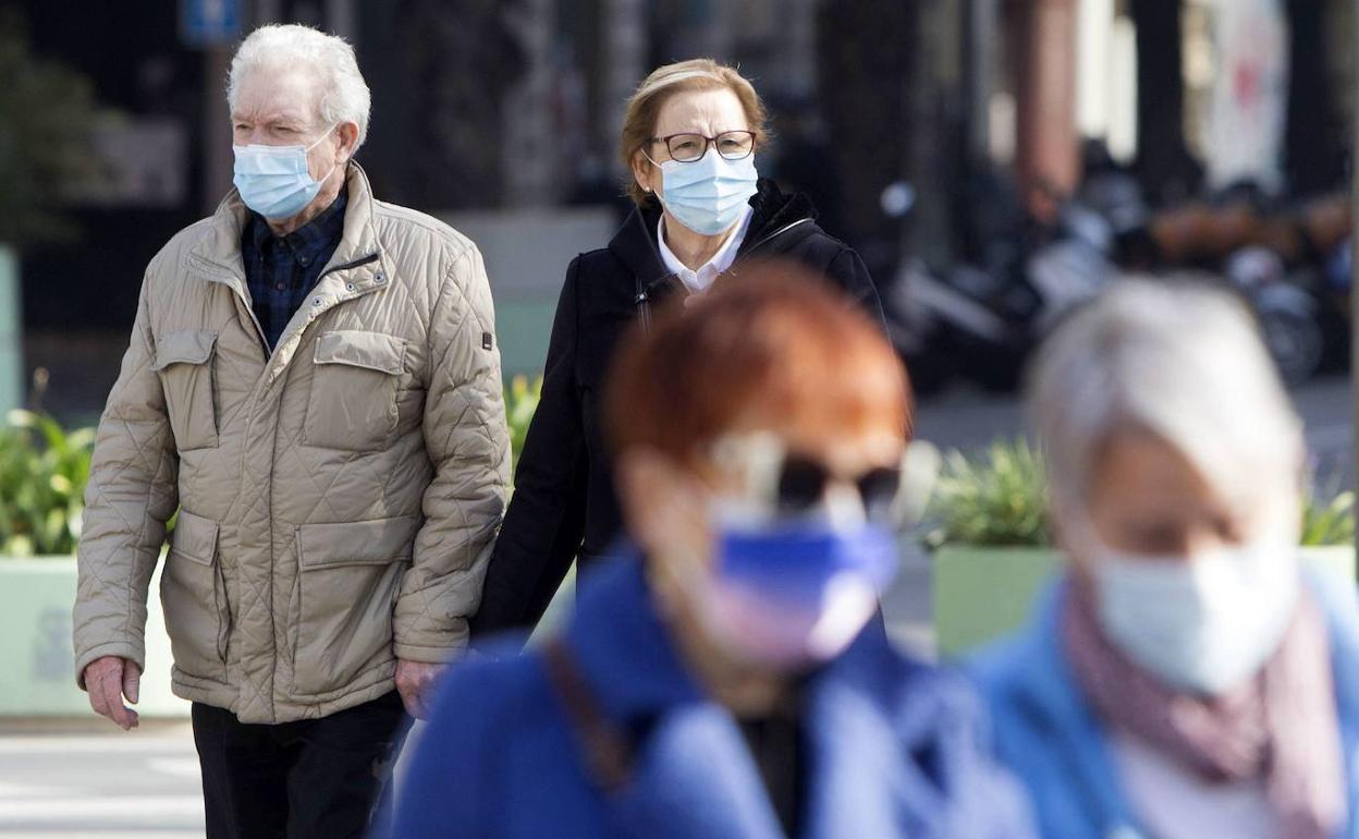 Unas personas con mascarilla por el centro de Valencia. 
