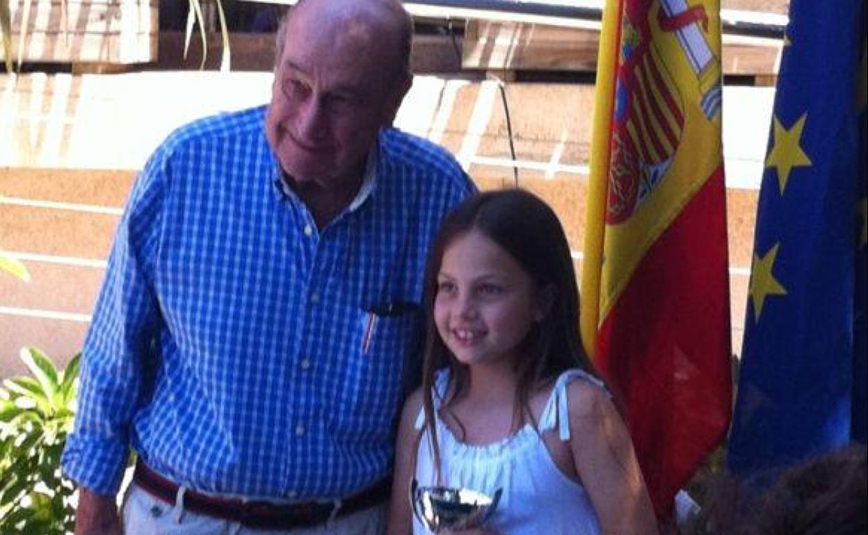 Lucía Garrigues, de pequeña, recogiendo un trofeo con su abuelo José Manuel Garrigues a su lado, orgulloso.