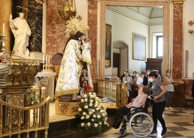 Imagen secundaria 1 - Cola del Besamanos, gente con abanicos y paraguas e interior de la Basílica. 