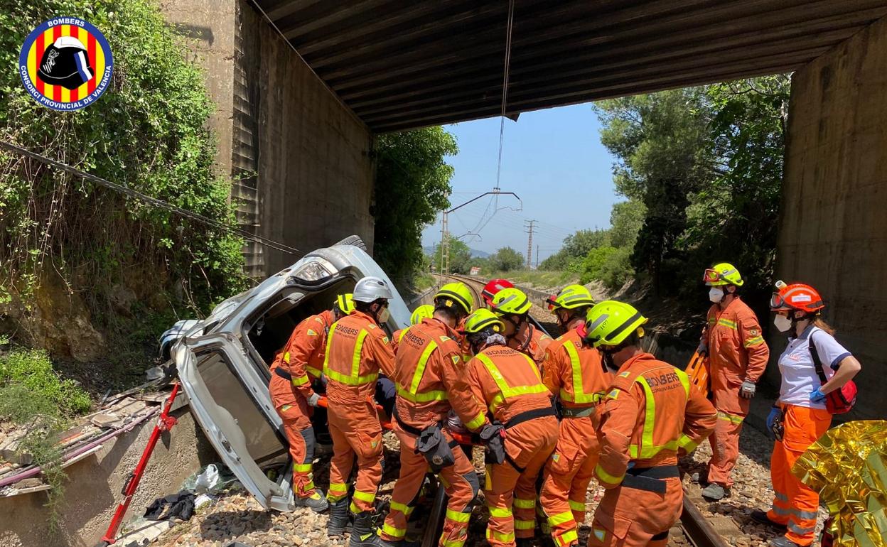 Momento en el que los bomberos liberan a la mujer del vehículo accidentado. 