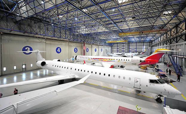 Imagen principal - Hangar. Vista general de parte de la zona de taller, que ocupa casi seis mil metros cuadrados. | Desmontaje. Según el nivel del mantenimiendo, en función de las horas de vuelo, se revisan más o menos partes de las aeronaves. 