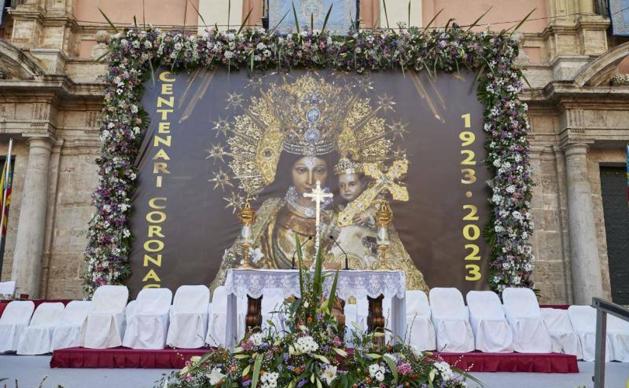 Lona oscura con la imagen de la Virgen que se instaló decorada con centros florales. 