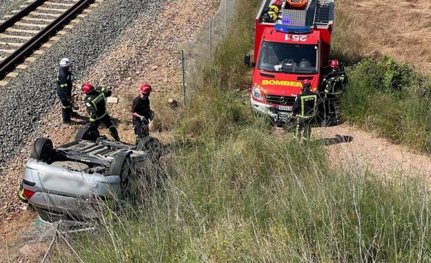 Imagen principal - Efectivos de bomberos trabajando en la zona del accidente. 