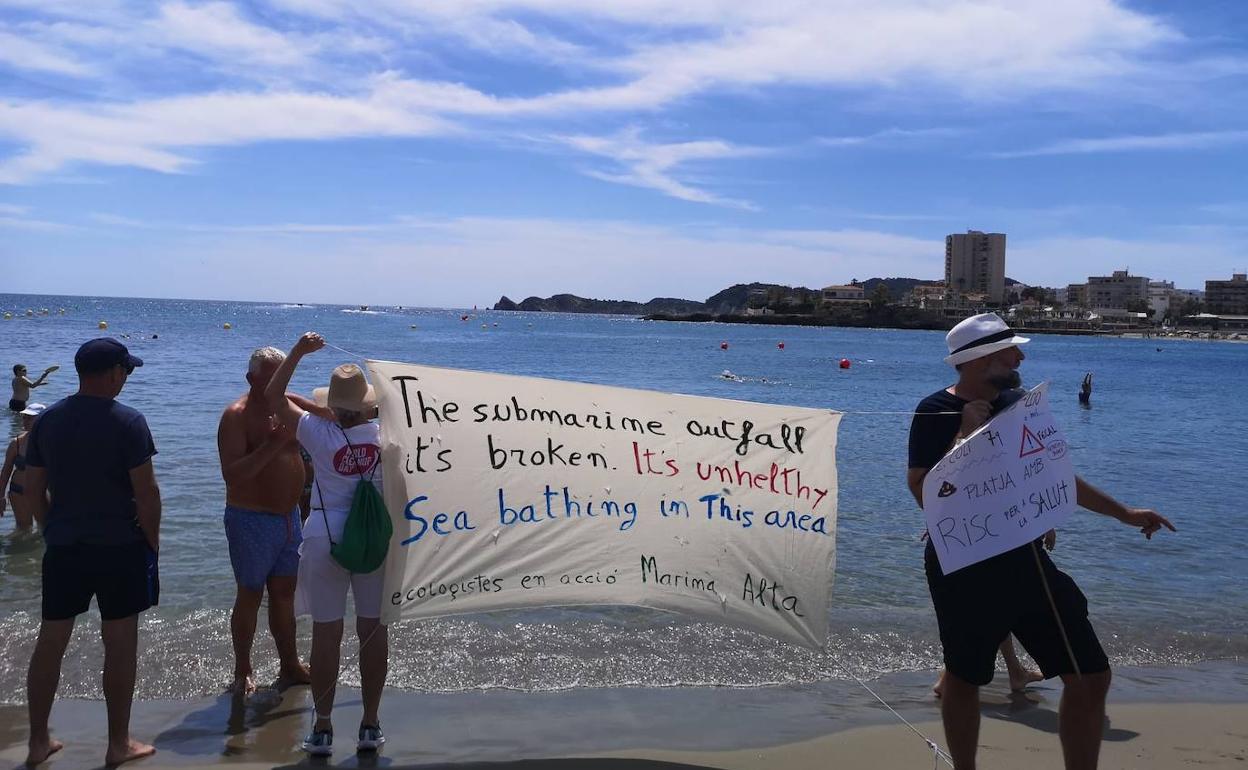 Miembros de Ecologistes en Acció de la Marina Alta con pancartas en la playa del Arenal de Xàbia. 