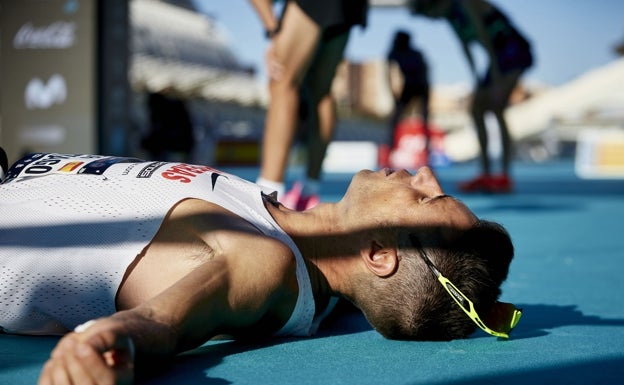 Un corredor del Maratón de Valencia, rendido en la línea de meta. 