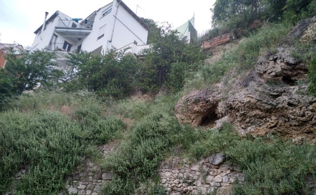 Imagen principal - (Arriba y izquierda) Ubicación de las viviendas, al borde de una ladera. (Derecha) Estado de a calle tras la caída de hojas y lluvia.  