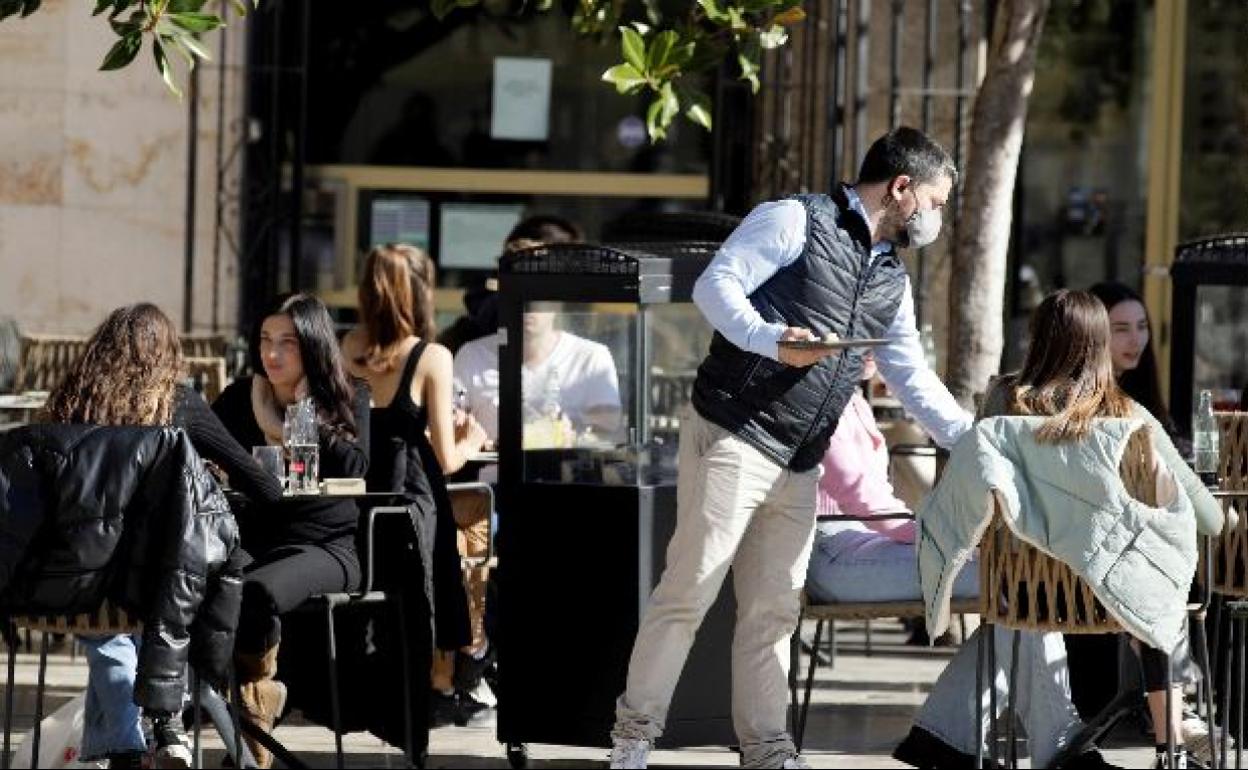 Un camarero trabaja en una terraza valenciana.