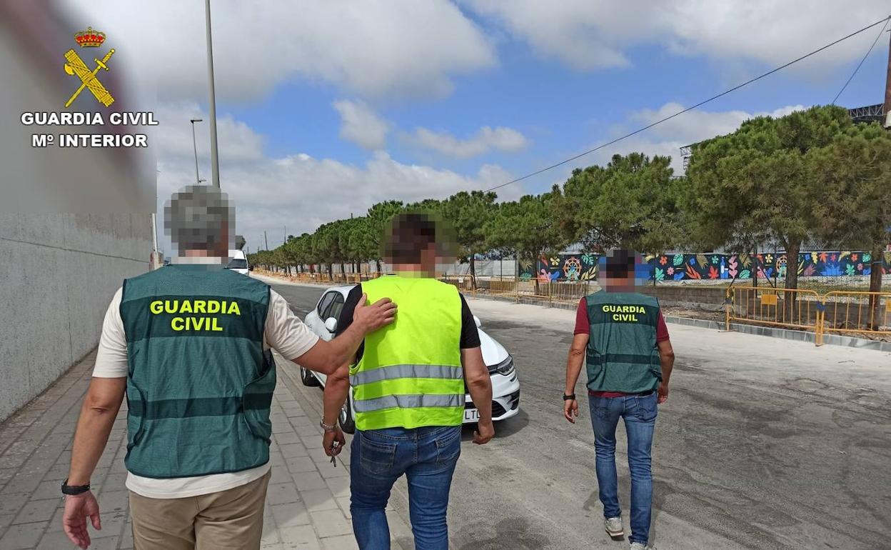 Dos agentes acompañan al camionero tras la detención. 