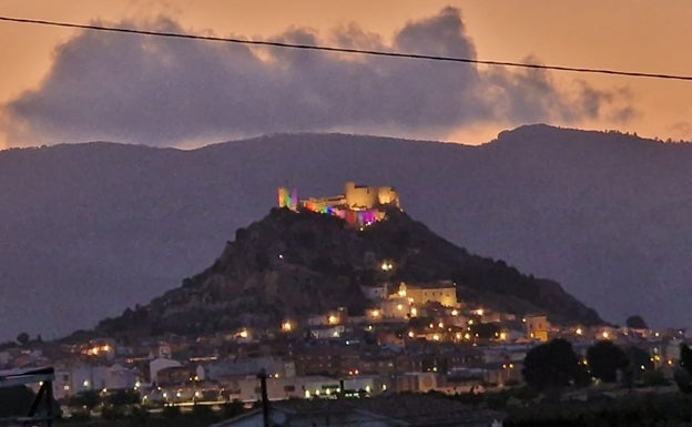 Imagen principal - (Arriba) Castillo de Castalla iluminado con los colores del arcoíris. (Abajo) Los Ayuntamientos de Muro e Ibi fueron escenario de la lectura de sendos manifiestos reivindicativos. 