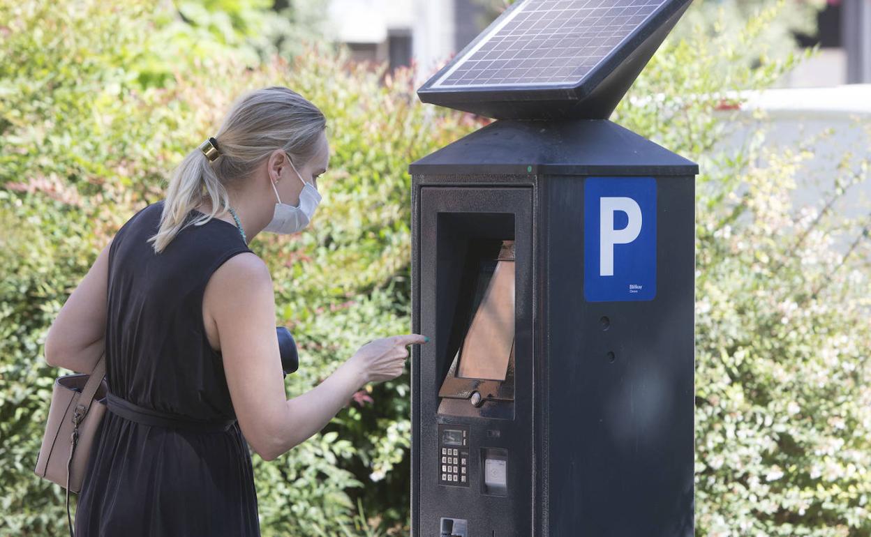 Una mujer paga en uno de los nuevos parquímetros de la ORA en Valencia.