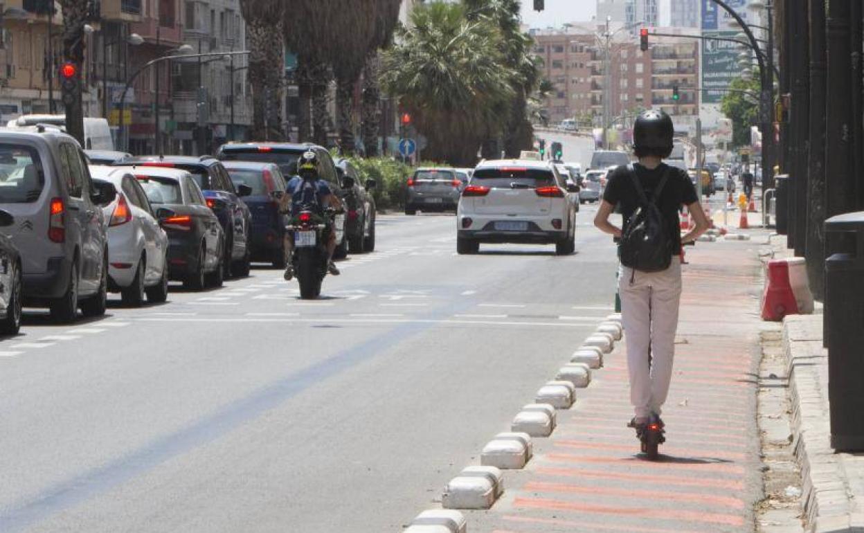 Atascos de coches en la avenida Pérez Galdós y conductor de patinete circulando por la ampliación táctica de la acera de peatones. 