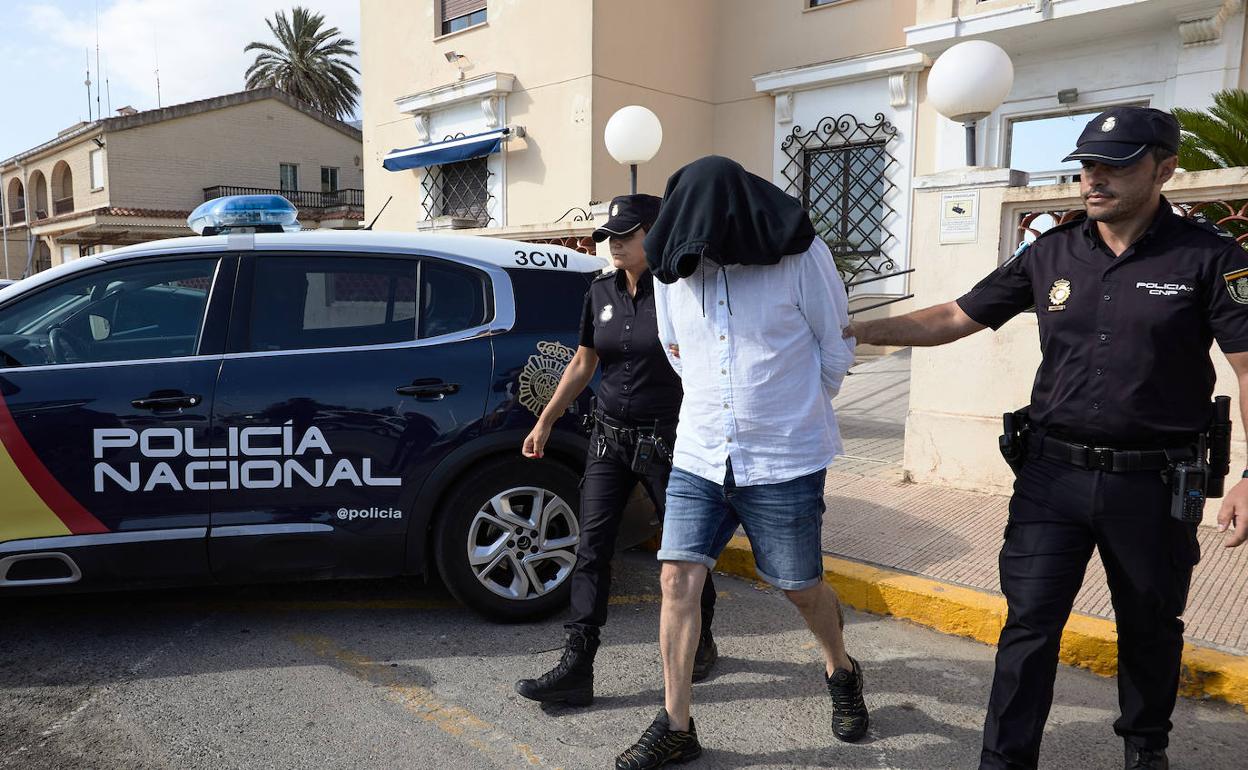 Dos agentes de la Policía Nacional trasladan a uno de los detenidos en Dènia. 