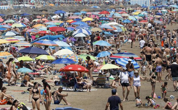 Miles de personas enplaya de la Malvarrosa de Valencia este sábado. 