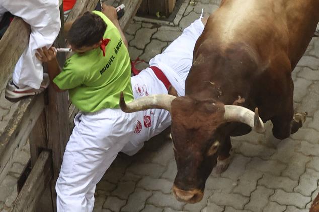 Los mozos, durante el octavo y último encierro de los Sanfermines con toros de la ganadería de Miura en el tramo final de entrada a la Plaza de Toros de Pamplona.