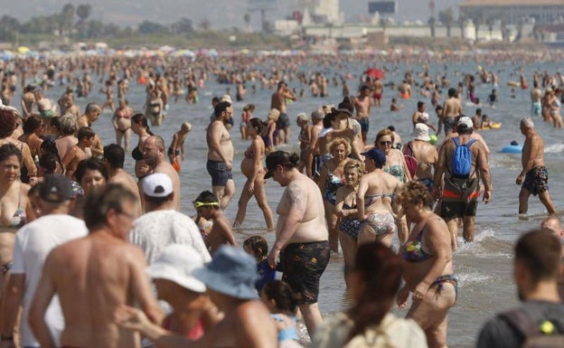 Gente refrescándose en la orilla del mar. 