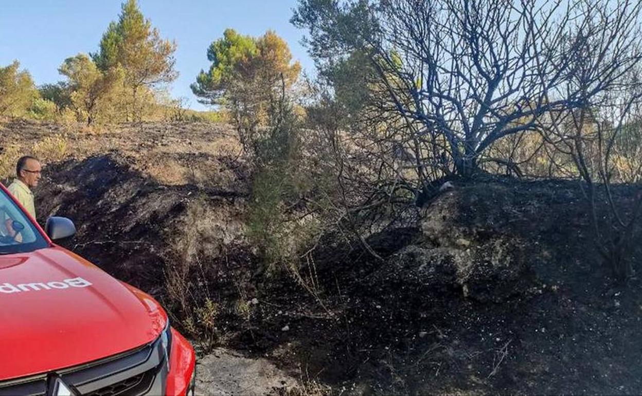 Un vehículo de bomberos junto a la zona afectada por el fuego en la Vall d'Alcalà. 