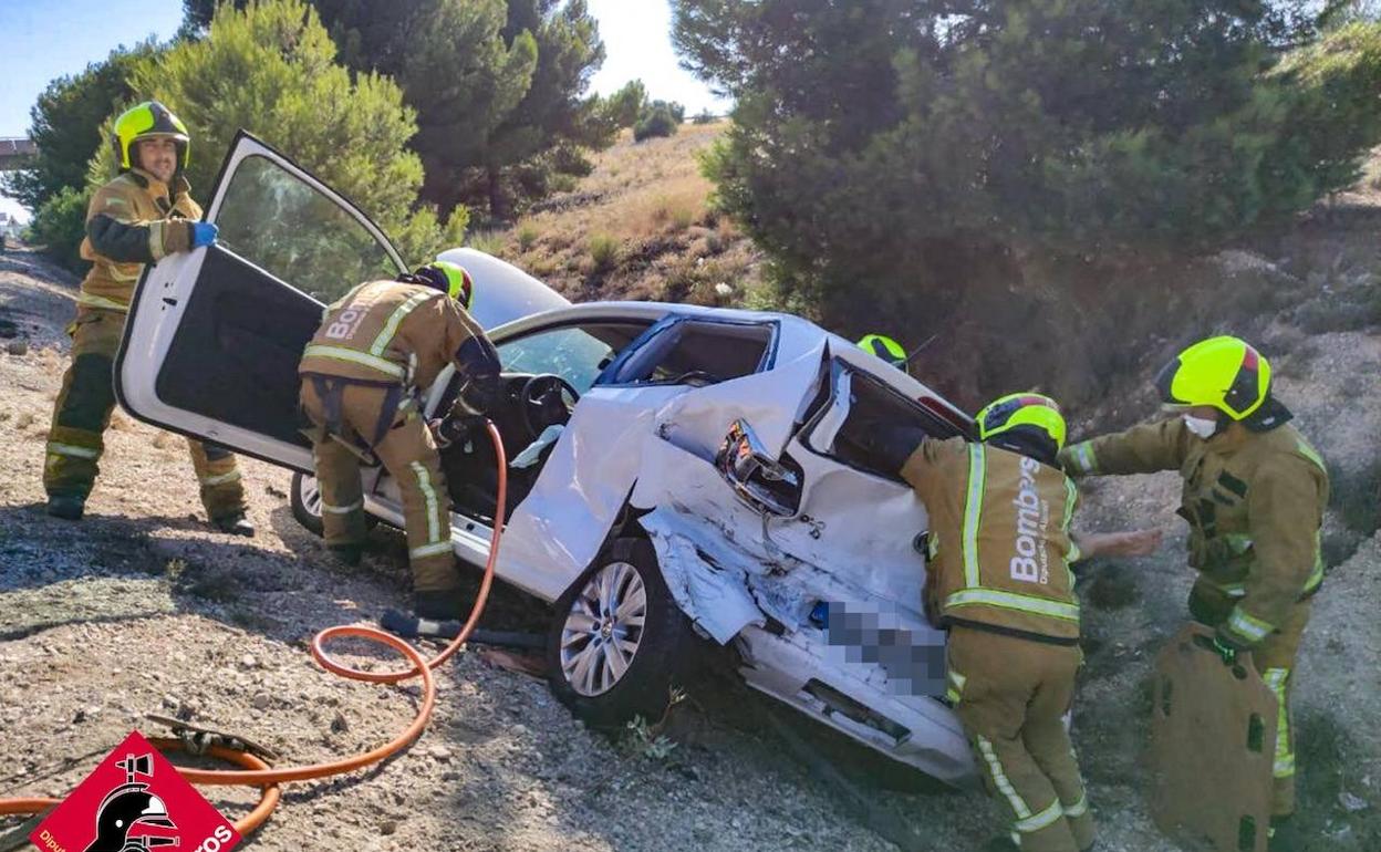 Los bomberos trabajan en la excarcelación de la mujer accidentada. 