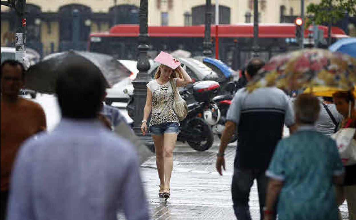 Una joven se pone a cubierto en Valencia un día de lluvia