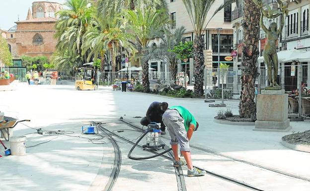 Operarios dando esplendor a las vías del antiguo tranvía de la plaza. 