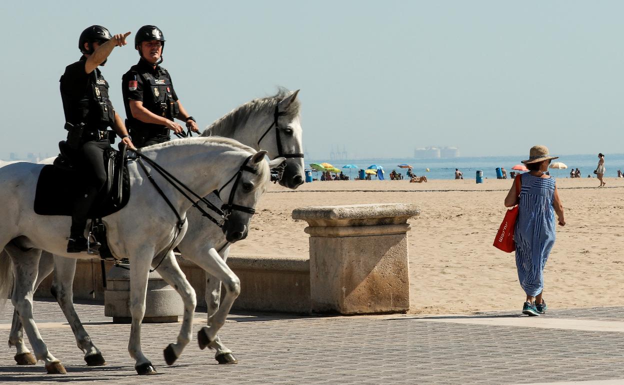 Agentes de la Policía Nacional recorren una playa de Valencia, en una imagen de archivo. 