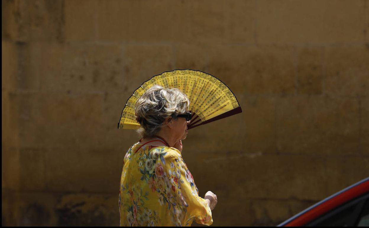 Imagen de archivo de una mujer cubriéndose con un abanico