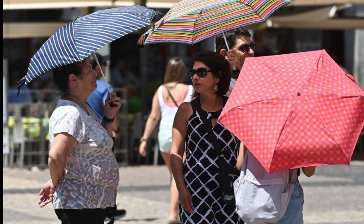 Varias personas protegiéndose del sol