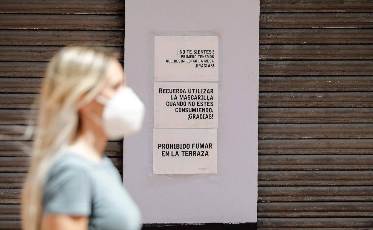 Una mujer se protege del Covid con una mascarilla.