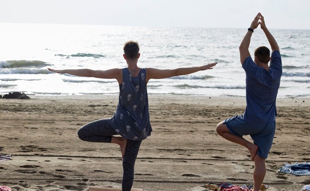 Alba y Javi, haciendo yoga en la playa.